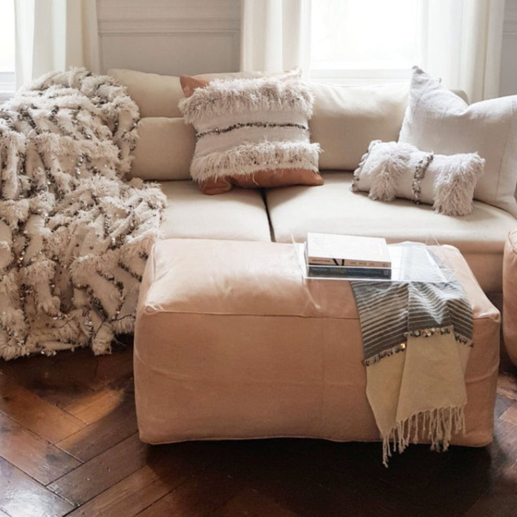Large nude Handcrafted Moroccan leather pouf, offering versatility and style as a seating option or decorative coffee table.