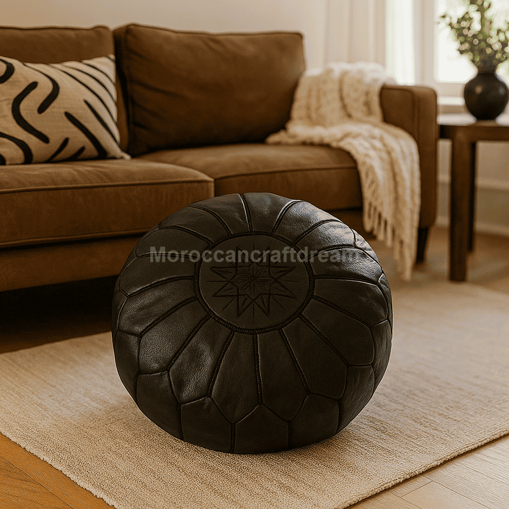 Black leather ottoman in a living room setting with a brown sofa and decorative pillows.