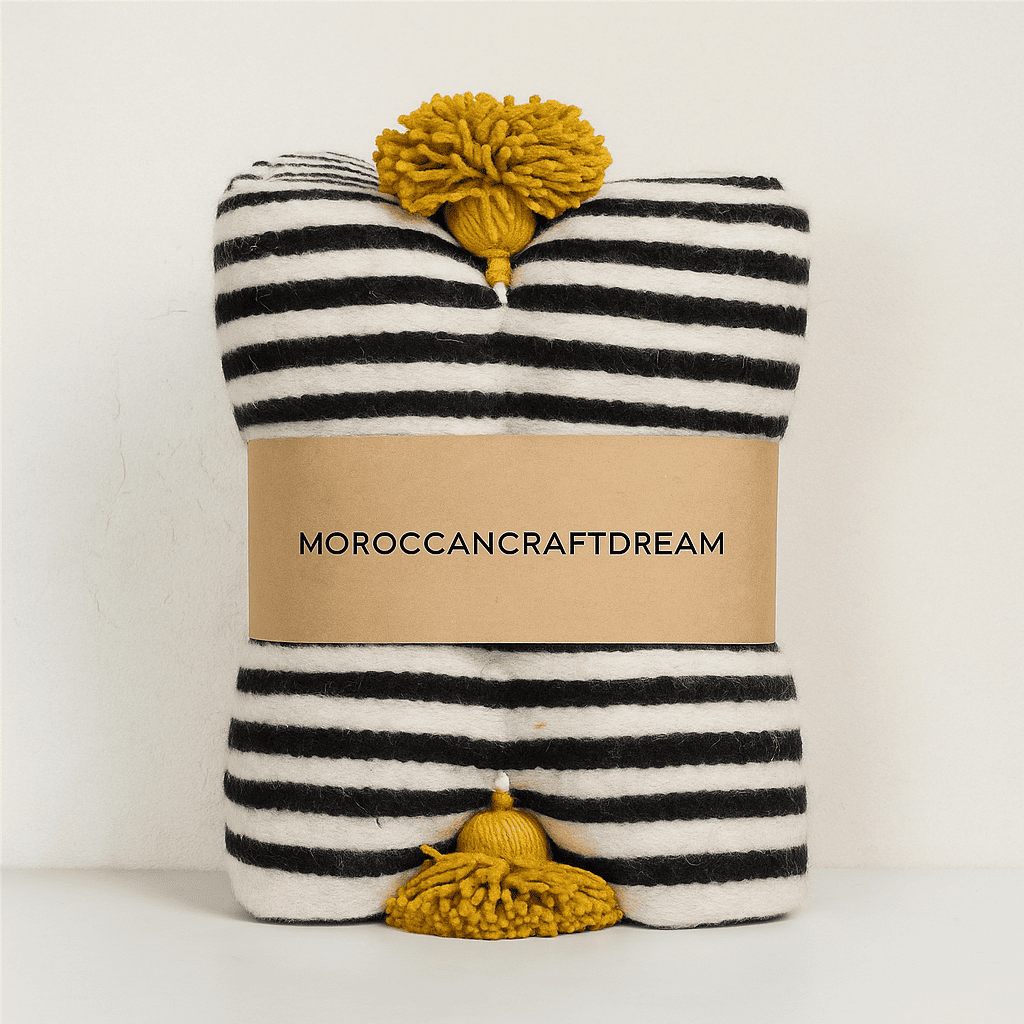 Striped fabric with pom-poms and 'Moroccancraftdream' label on a white background