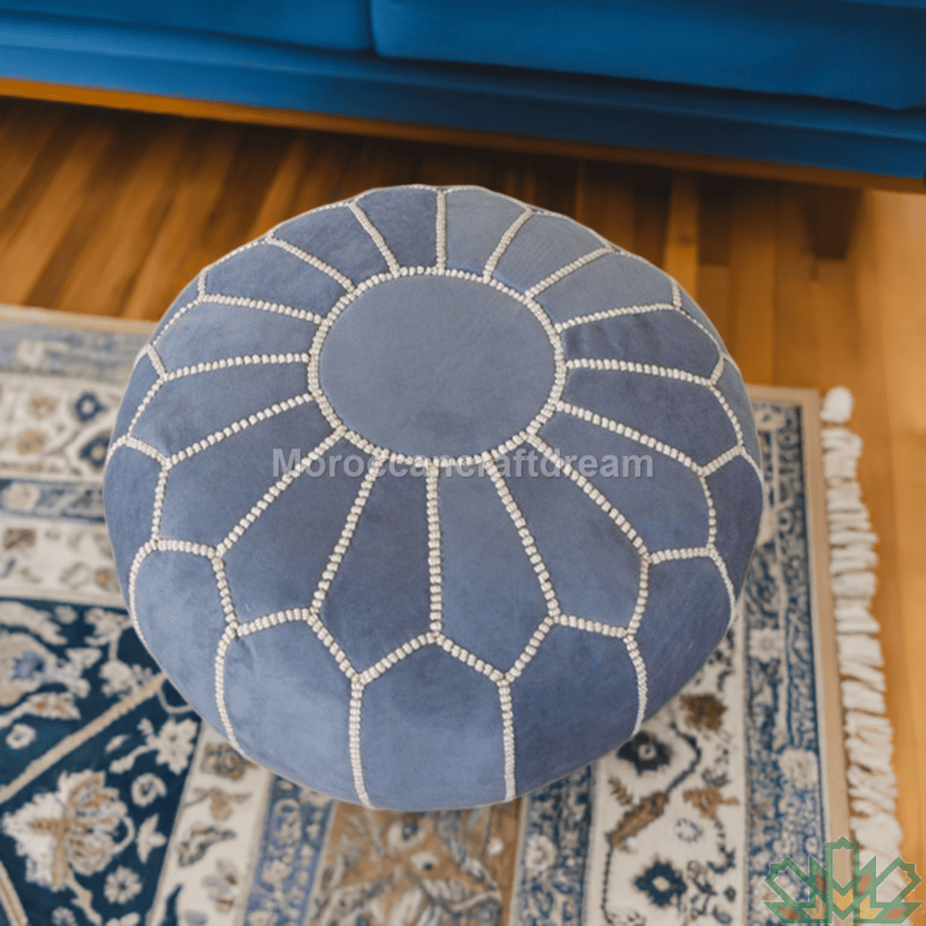 Blue ottoman with white stitching on a patterned rug