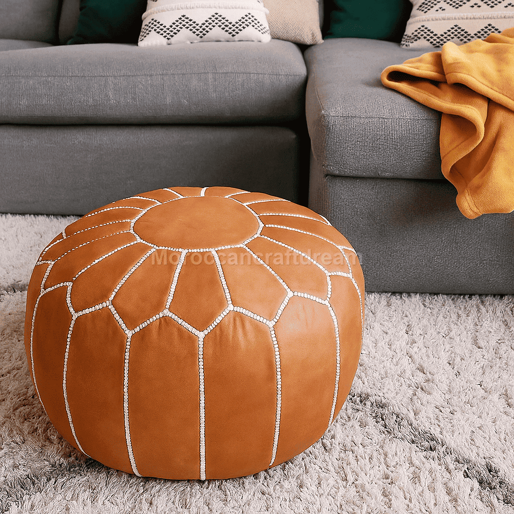 Brown leather pouf with diamond pattern on a gray carpet in a living room setting.