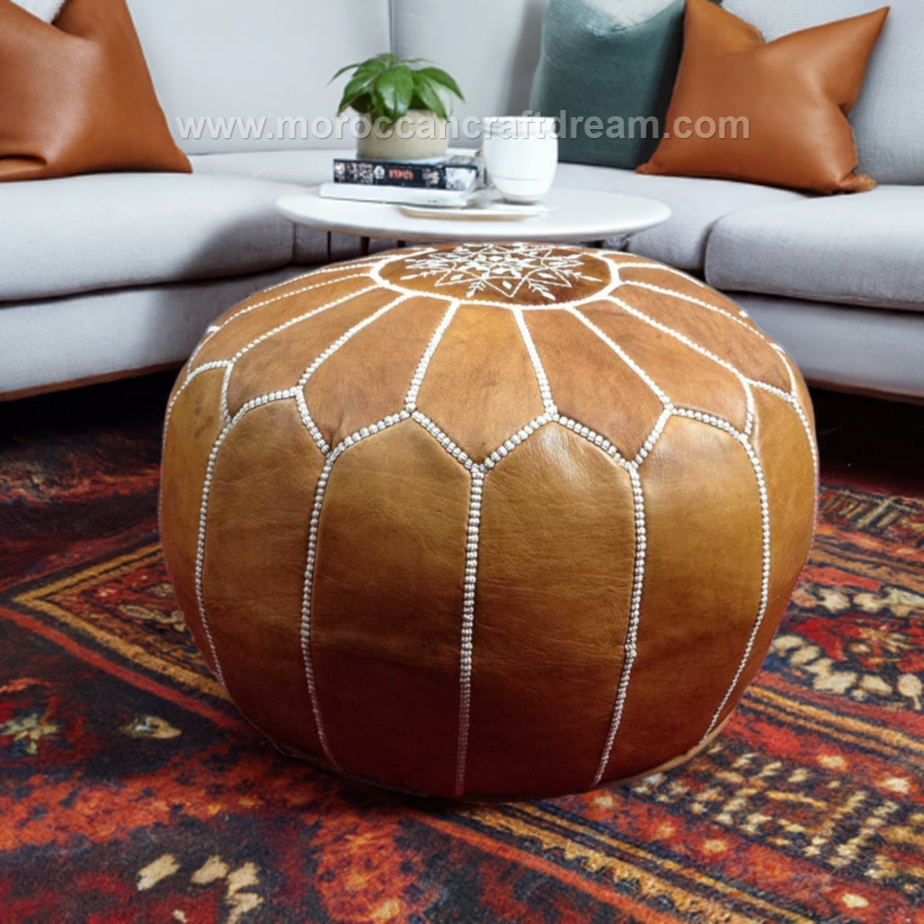 Moroccan pre-stuffed light caramel leather ottoman used as a coffee table or footstool, combining style and versatility for elegant home settings.