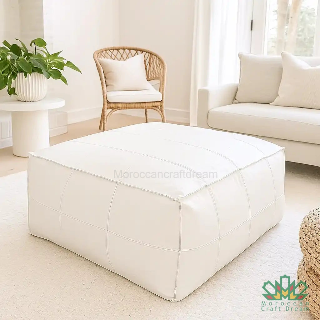 White leather ottoman in a living room setting with a chair and sofa, used as coffee table and chair.