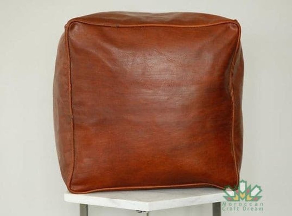 Handcrafted leather Moroccan poufs, ottomans and footstool in tan tones, featuring traditional stitching and soft, durable materials.