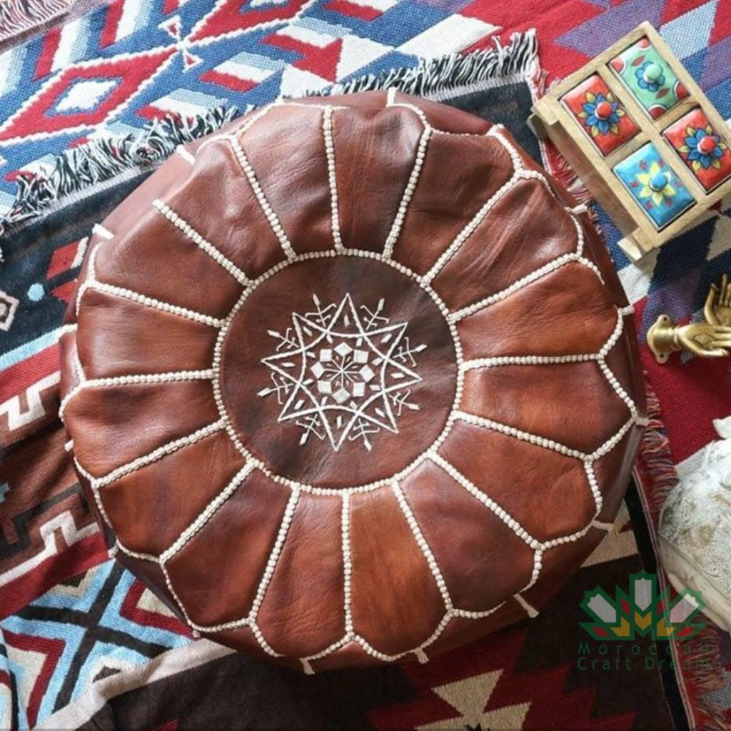 Round Moroccan leather poufs used as a coffee table, handcrafted with durable materials and traditional stitching in natural tones.