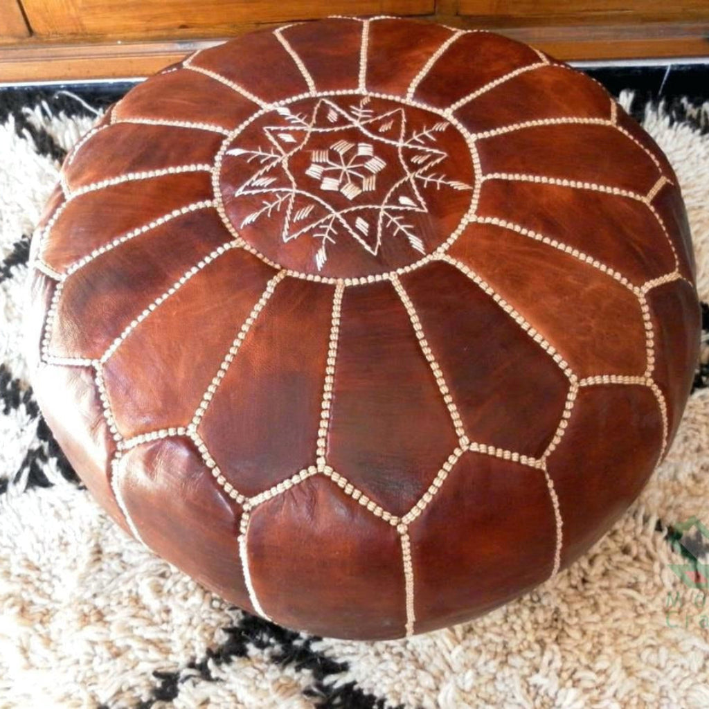 Round Moroccan leather poufs used as a coffee table, handcrafted with durable materials and traditional stitching in natural tones.