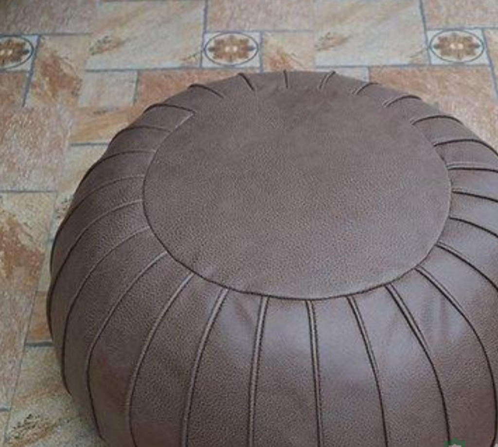Round Handcrafted Moroccan leather pouf for living room decor, blending comfort with authentic Moroccan style.