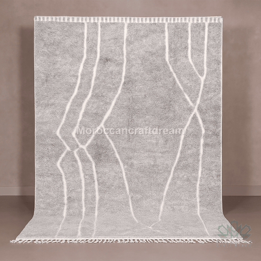 Gray rug with white patterns and fringes on a brown background
