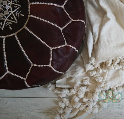 Handcrafted Moroccan leather poufs, ottomans and footstool in natural tones, featuring traditional stitching and soft, durable materials.