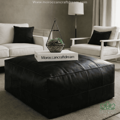 Black leather ottoman coffee table in a modern living room with 'Morocancraftdream' branding.