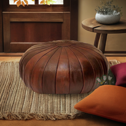 Round brown Moroccan pouf used as a coffee table & footstool, handcrafted with durable materials and traditional stitching in natural tones.