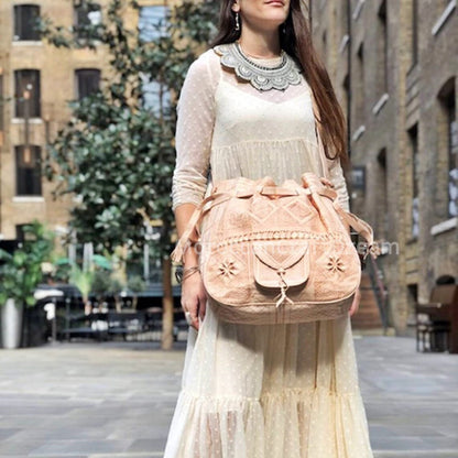 Woman holding a pink backpack in an urban setting