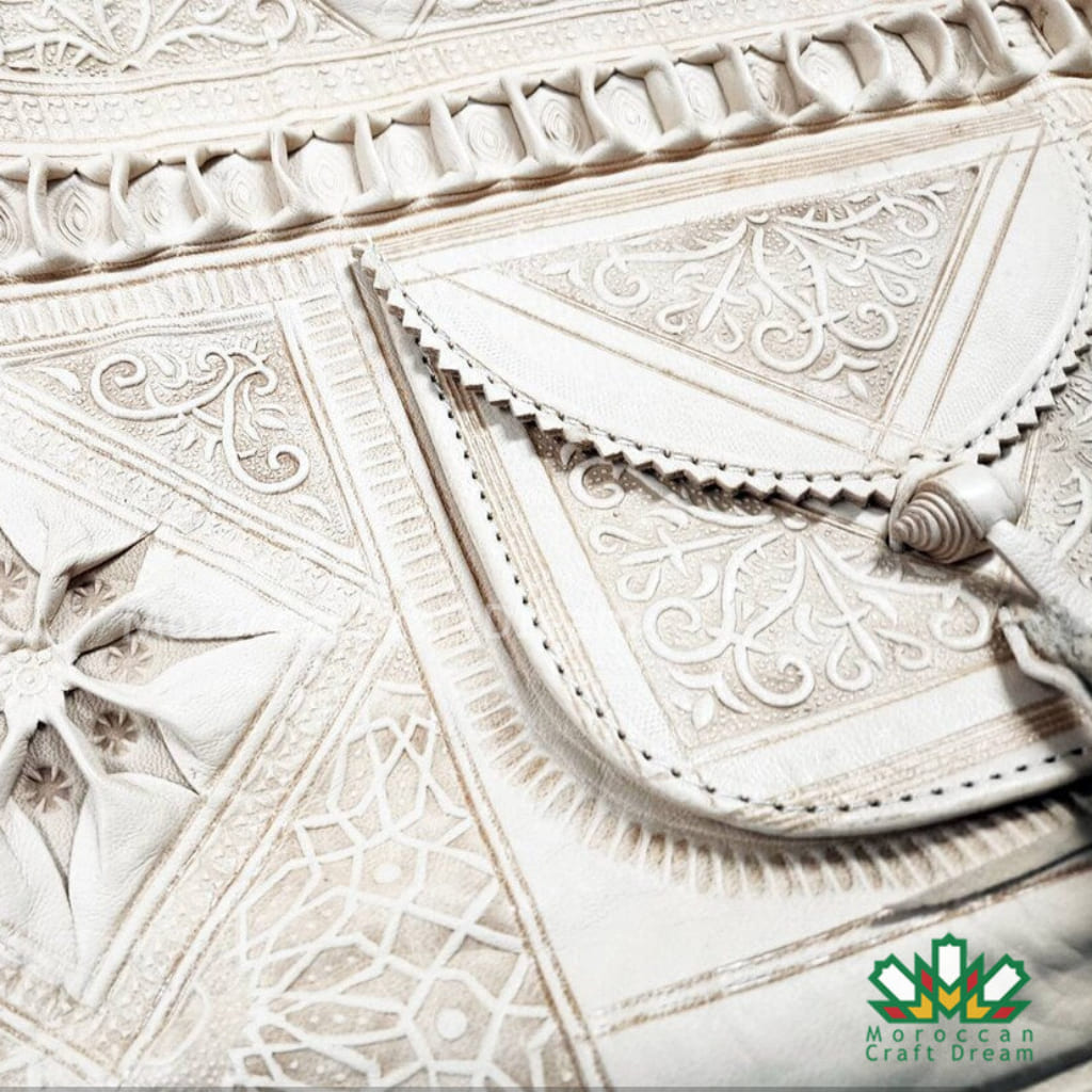 Close-up of intricate white tile patterns with 'Moroccan Craft Dream' logo.