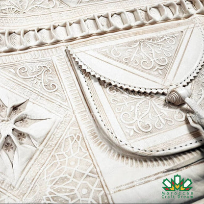 Close-up of intricate white tile patterns with 'Moroccan Craft Dream' logo.