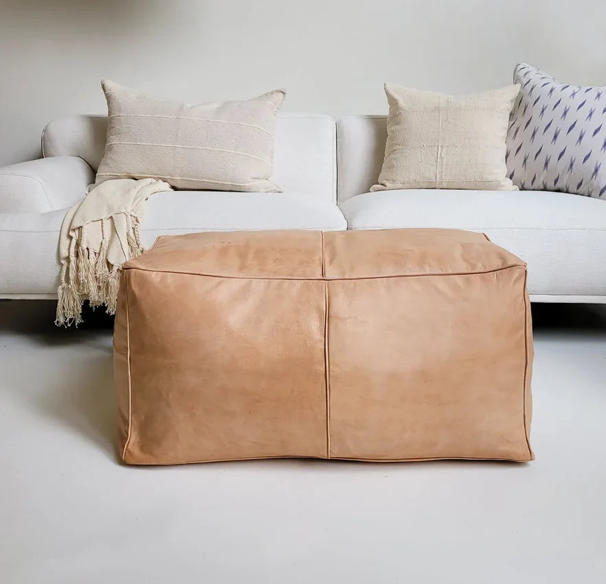 Square and rectangular Moroccan leather poufs used as coffee table ottomans, handcrafted with traditional stitching and durable materials