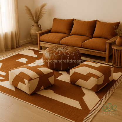 Cozy living room with brown sofa, ottomans, and patterned rug.