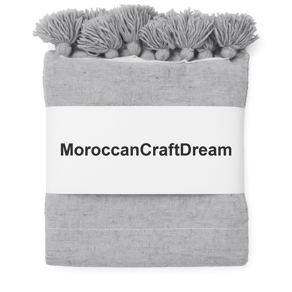 Gray blanket with tassels and 'MoroccanCraftDream' branding on a white background