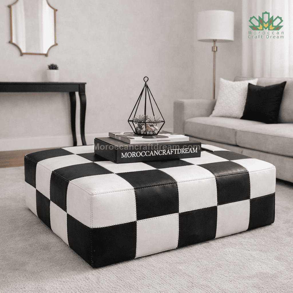 Black and white checkered leather coffee table in a living room setting with a gray sofa and lamp.