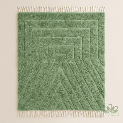 Green textured rug with white fringe on a beige background