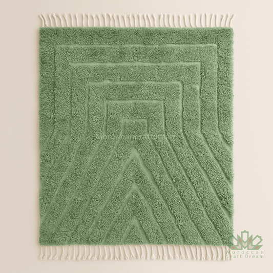 Green textured rug with white fringe on a beige background