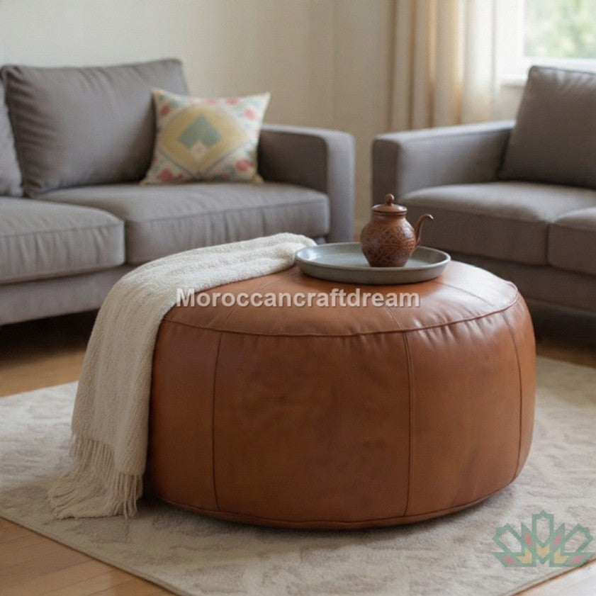 Brown leather ottoman with a blanket and decorative items in a living room setting.