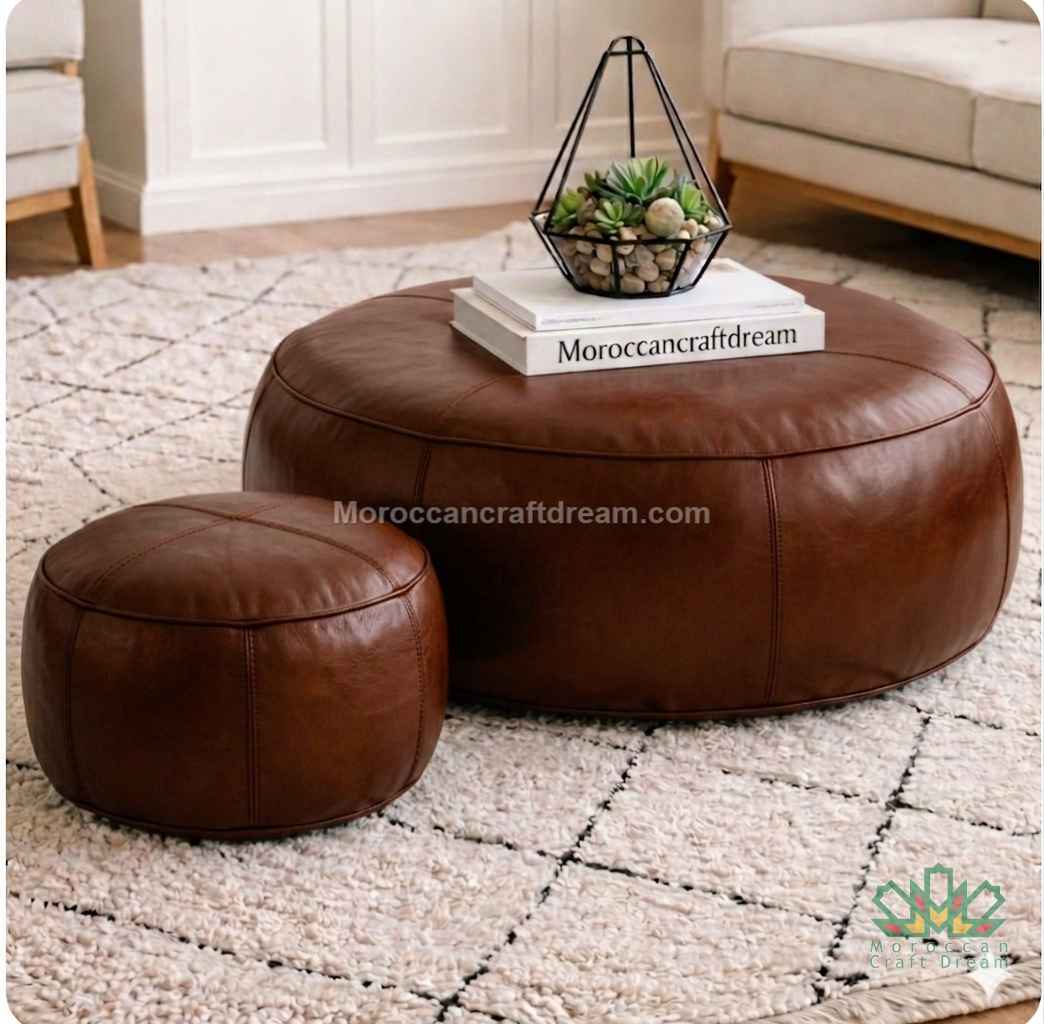 Brown leather ottoman and pouf on a patterned rug with 'MoroccanCraftDream' branding.