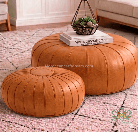 Two caramel leather ottomans on a patterned rug with a small plant pot on top.