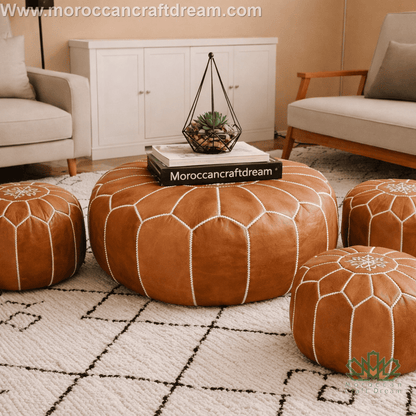 Caramel leather pouf with geometric pattern in a living room setting, featuring Moroccan Craft Dream branding.