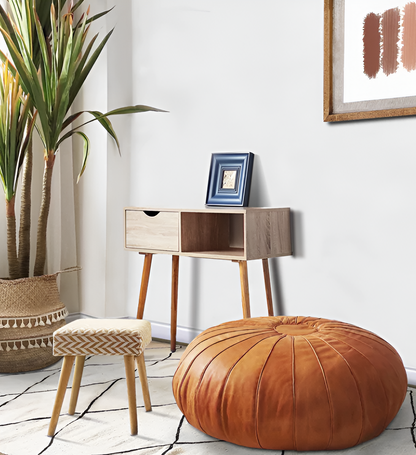 Handcrafted leather Moroccan poufs, ottomans and footstool in natural tones, used as a coffee table featuring traditional stitching and soft, durable materials.