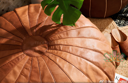 Round Moroccan leather poufs used as a coffee table, handcrafted with durable materials and traditional stitching in natural tones.