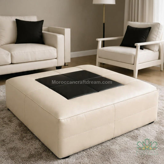 Beige ottoman with black top in a living room setting
