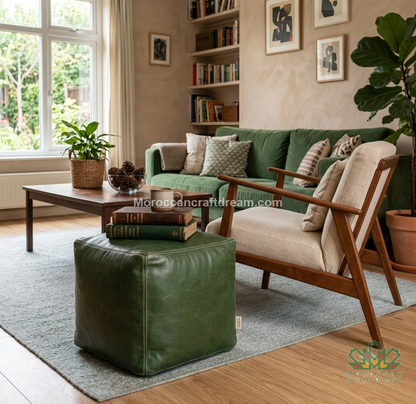 A mid-century modern living room featuring a green leather sofa and matching green leather ottoman, paired with a beige armchair, a wooden coffee table, and a gray rug.