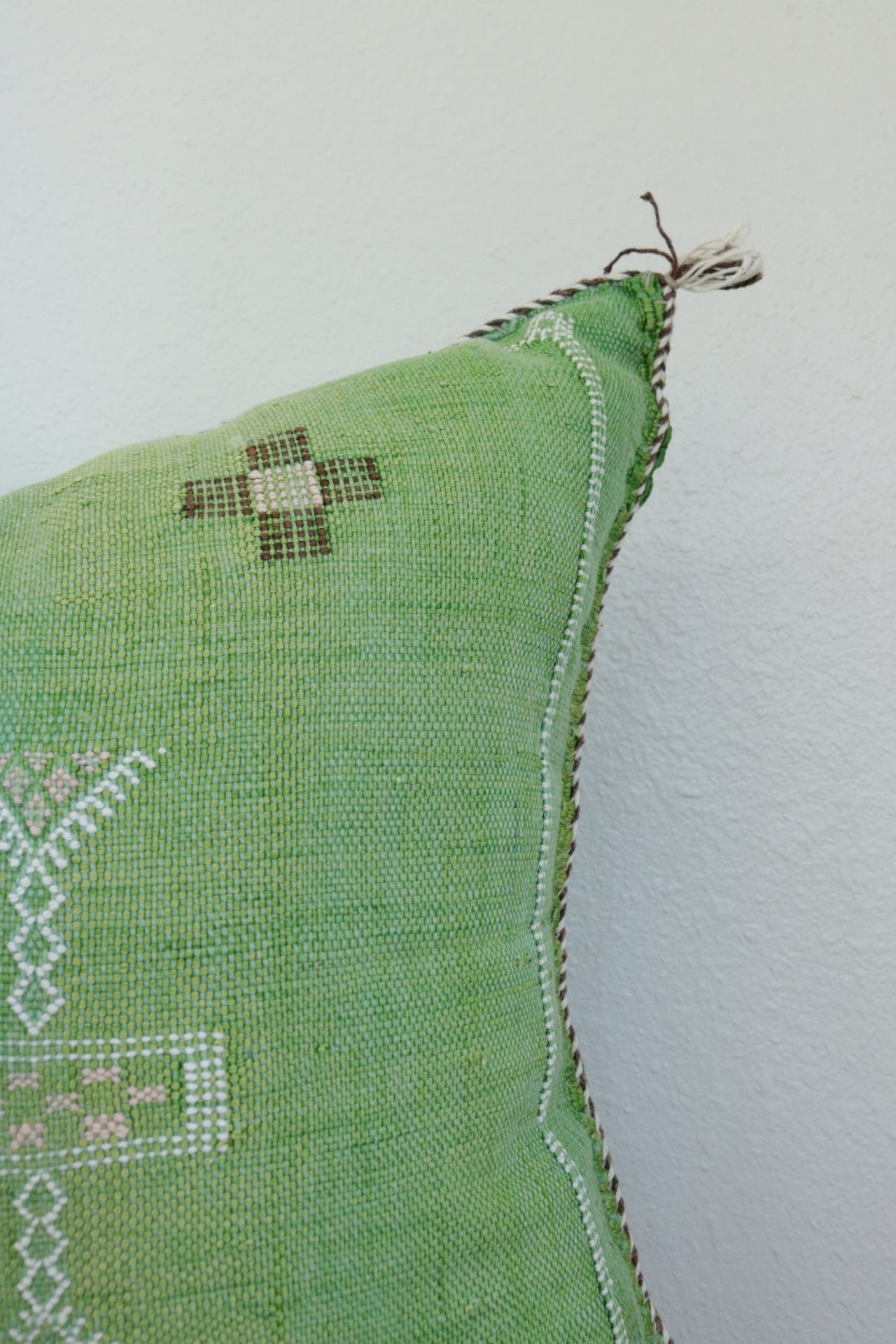 Close-up of Moroccan hand-loomed cactus silk green pillow with vibrant colors