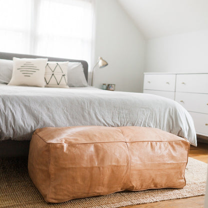 Large light caramel leather coffee table ottoman, ideal for modern decor and functional as a centerpiece for any living room.