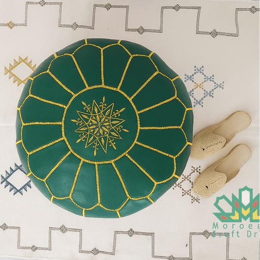 Green moroccan pouf, a decorative plate with gold patterns on a white surface with slippers.