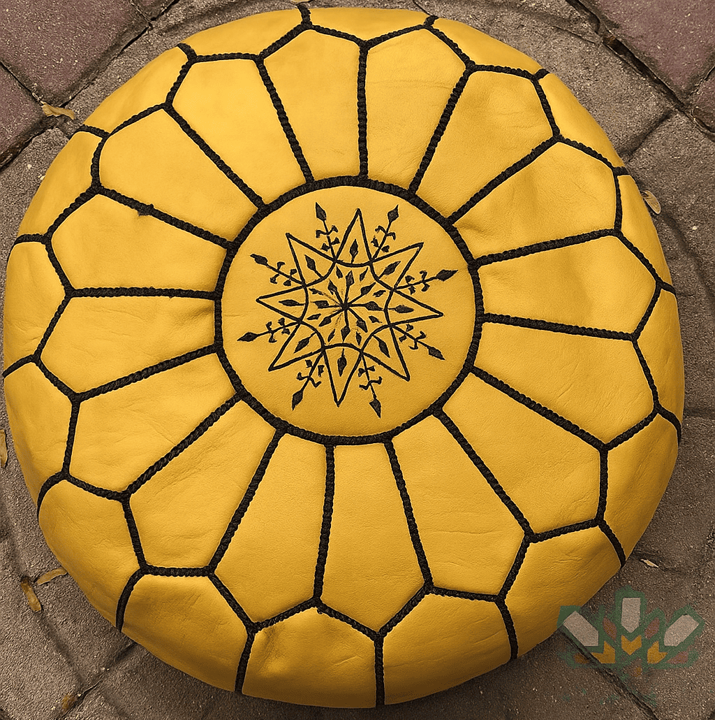 mustard leather moroccan pouf with geometric pattern on a stone pavement