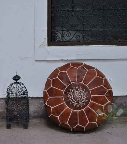 Tan handmade Moroccan leather pouf ottoman in neutral tones, designed for living room decor and additional seating.