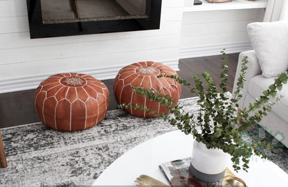 Handmade Moroccan leather pouf ottoman used as a coffee table, in authentic goatskin leather, perfect for versatile home decor, the color is tan.