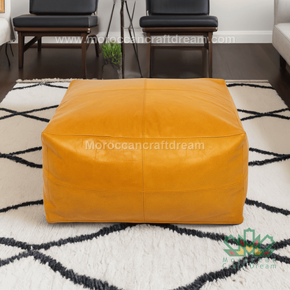 Mustard leather ottoman on a patterned rug with 'Moroccan Craft Dream' branding.