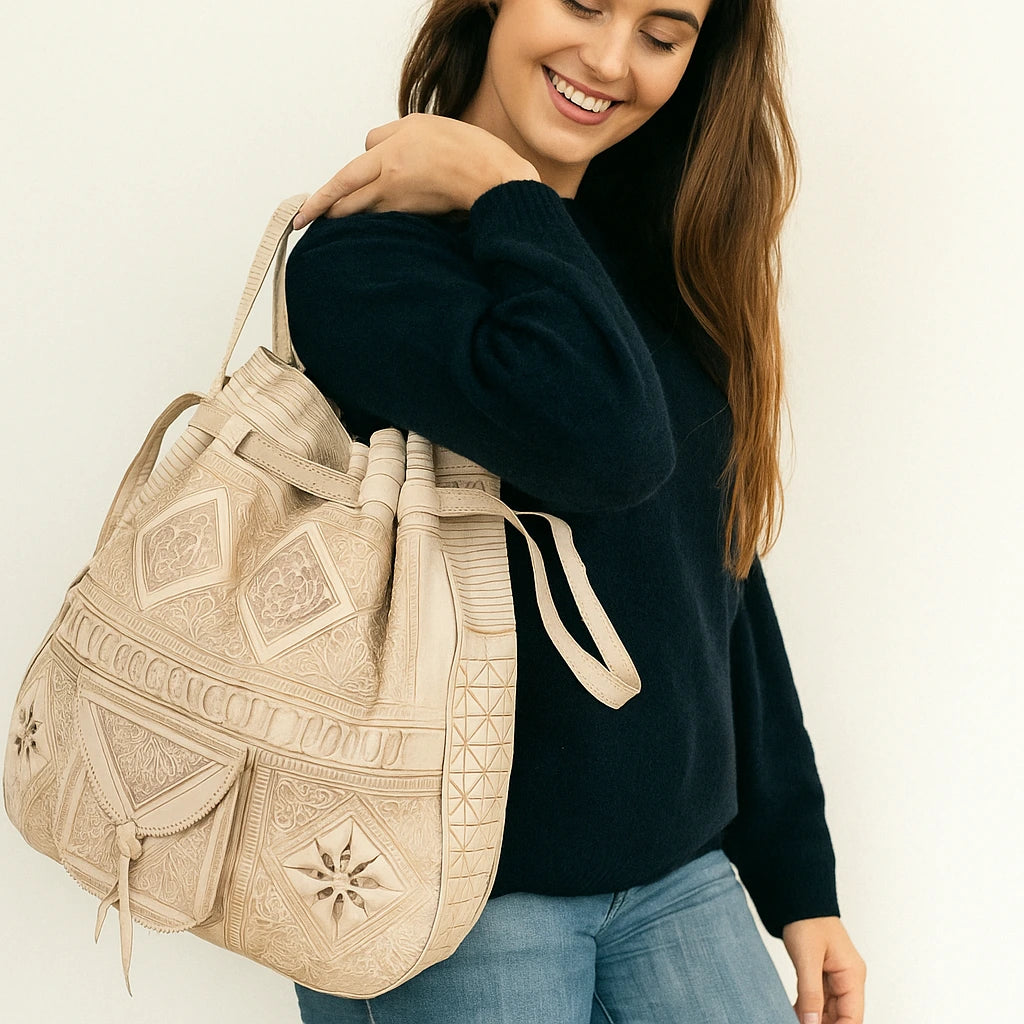 Woman holding a beige embroidered bag against a white background