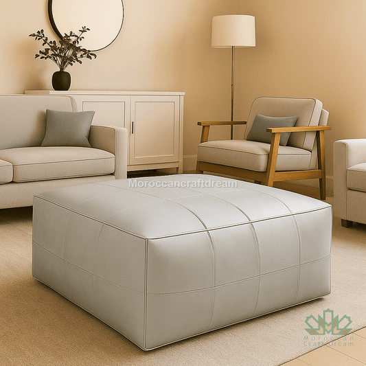 Beige living room with a sofa, armchair, and ottoman, featuring 'MoroccanCraftDream' branding with pearl gray leather ottoman coffee table.