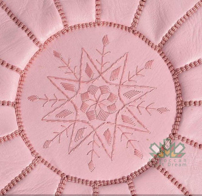 Moroccancraftdream pink leather pouf ottoman with geometric patterns, offering versatile use as a seat, footrest, or coffee table.