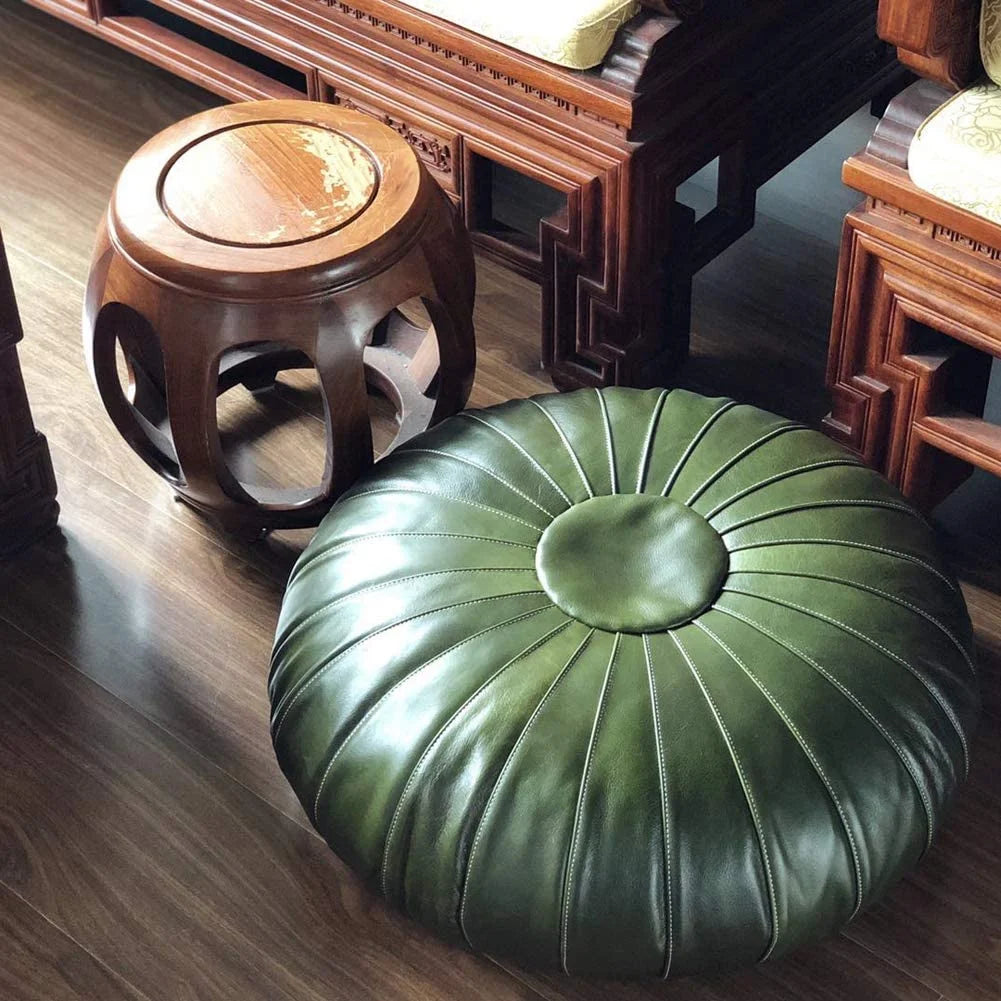 Handcrafted round leather ottoman used as foot stool coffee table or pouf with intricate Moroccan design, perfect for adding a touch of artisanal elegance to modern or bohemian home decor.