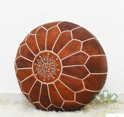 Handmade tan Moroccan leather pouf ottoman used as a coffee table, in authentic goatskin leather, perfect for versatile home decor.