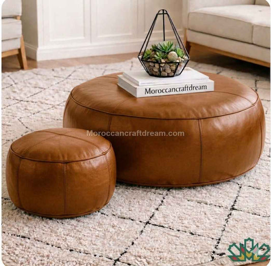 Tan leather ottomans on a patterned rug with a decorative item on top.