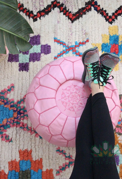 Luxurious pink leather Moroccan pouf ottoman by Moroccancraftdream, used as a footrest or extra seating option.