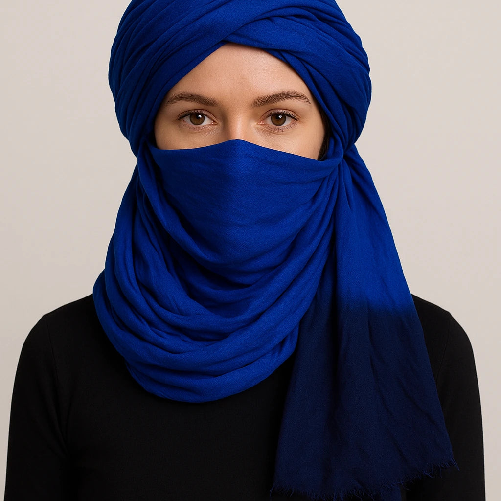 Person wearing a blue headscarf and face covering against a neutral background
