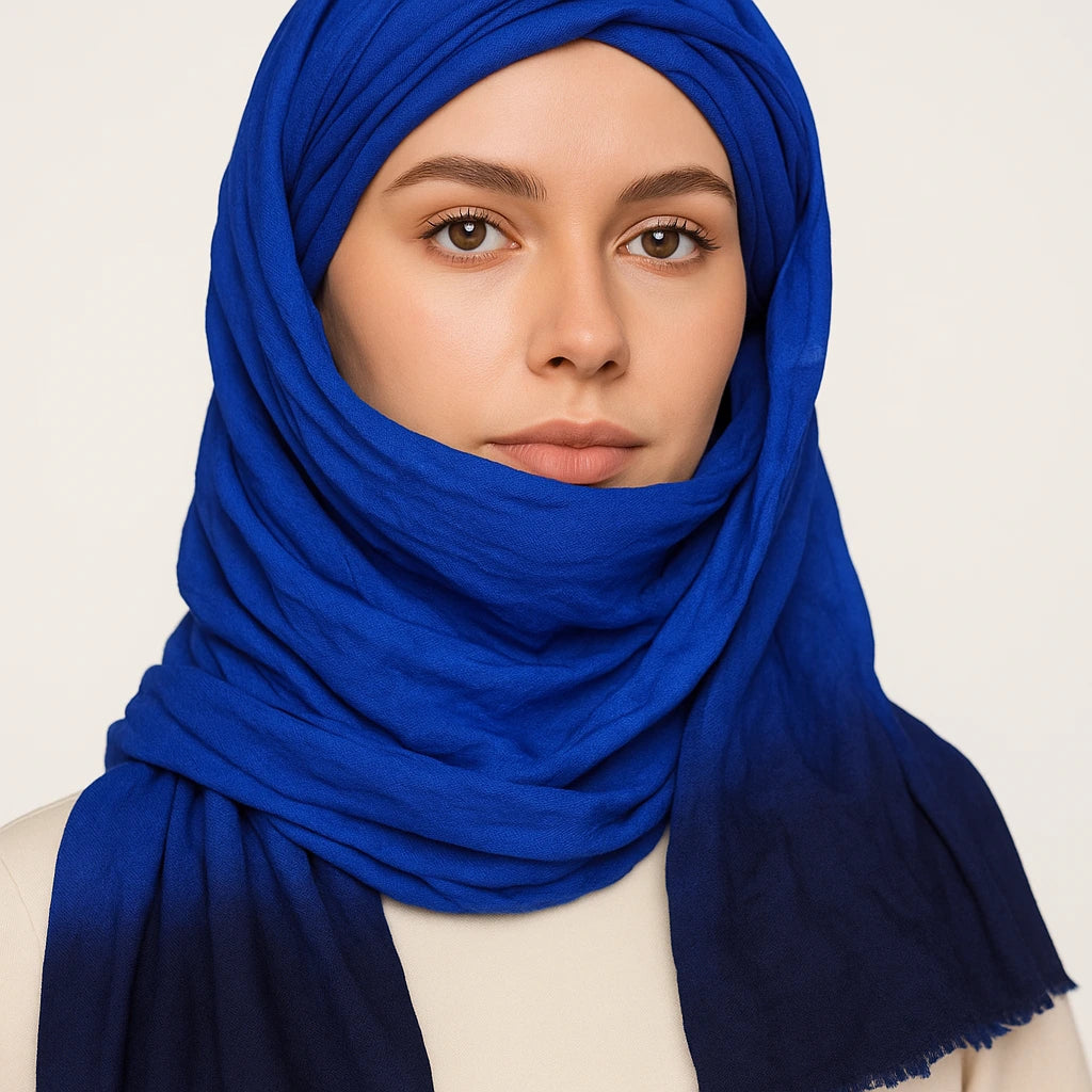 Woman wearing a blue hijab against a plain background