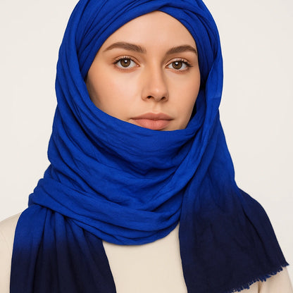 Woman wearing a blue hijab against a plain background