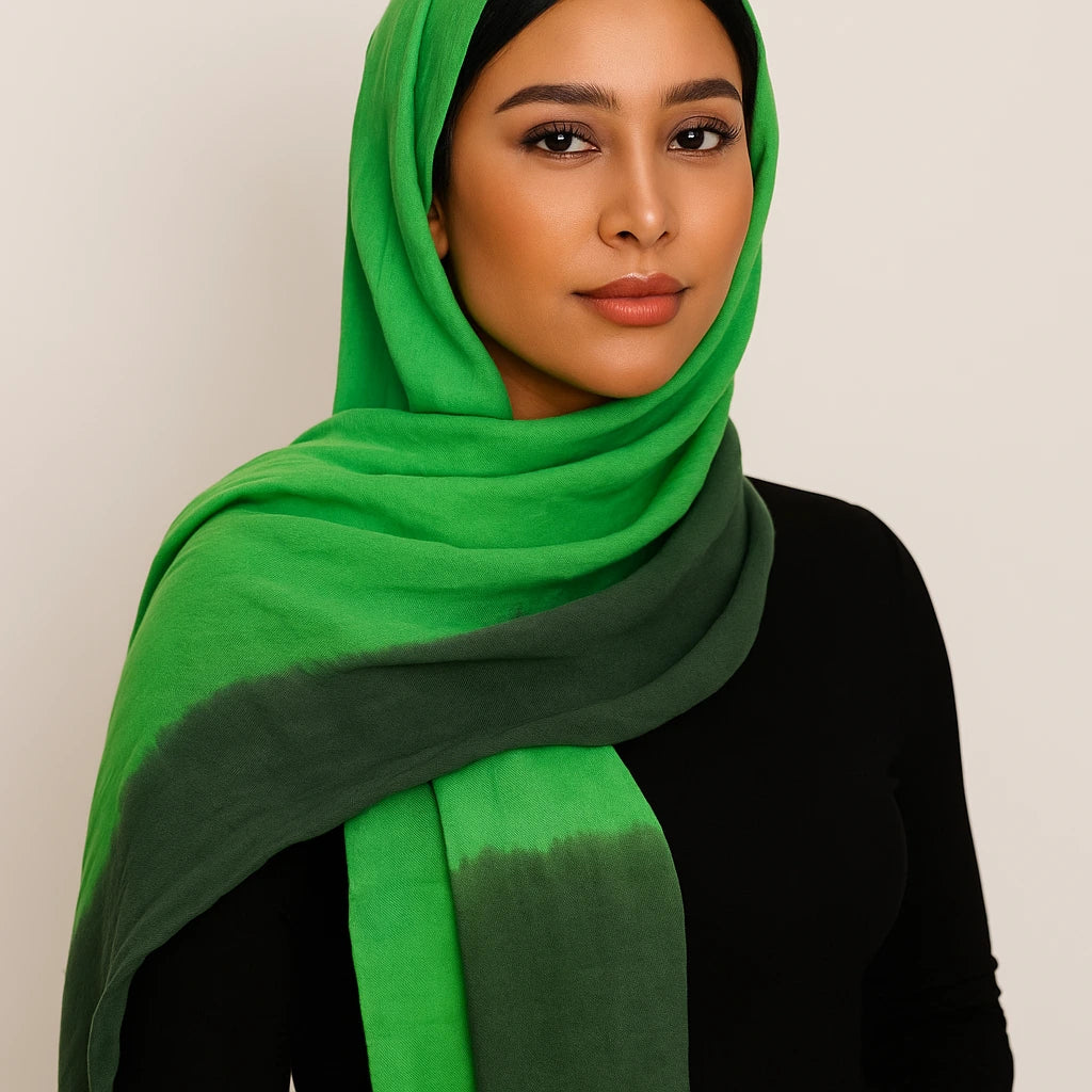 Woman wearing a green hijab against a plain background